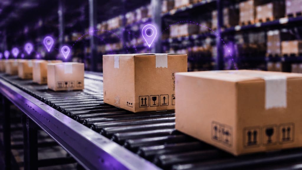 Caixas de pedidos em esteira de centro de distribuição com rastreamento logístico.